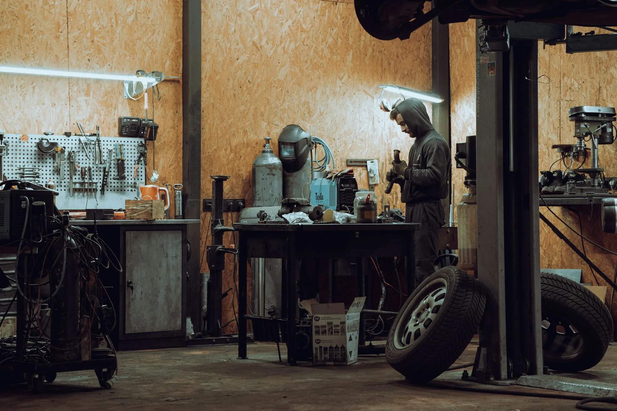 Inside an auto repair workshop with tools and a lift